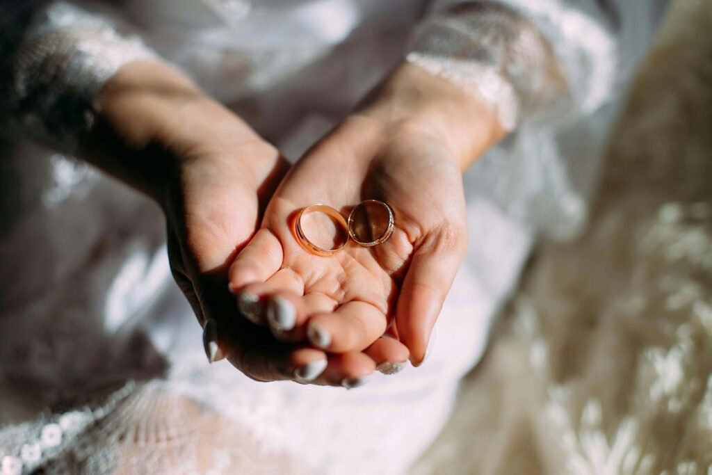 Manos de una pareja sosteniendo sus anillos de boda